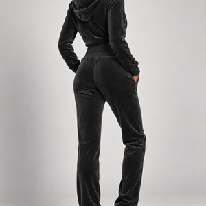 High-fashion model wearing The Icon Velour Hooded Set in black, back view